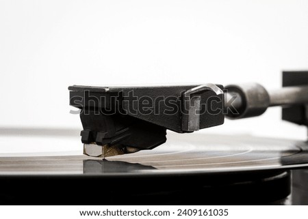 Close up of turntable needle on a vinyl record. Turntable playing vinyl. Needle on rotating black vinyl. Royalty-Free Stock Photo #2409161035