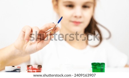 paintbrush on white background with little girl. copy space. Shallow depth of field