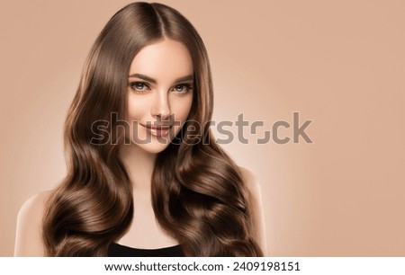 Beauty girl with long  and   shiny wavy hair .  Beautiful   woman model with curly hairstyle .
