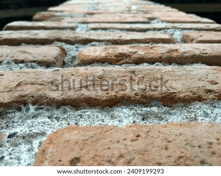 A brick pillar that is old but still looks sturdy.