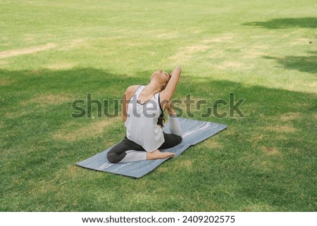 Young women have a beautiful bodies, Playing yoga in an elegant posture, in the green park, is a concept of people's recreation and health care concept. blurred background