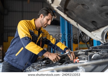 latin auto mechanic man checking and using wrench maintenance engine in garage cars service . hispanic technician repairing vehicle at garage . maintenance car repair service Royalty-Free Stock Photo #2409213353