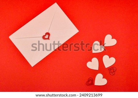 Enveloped Love: A Heartfelt Composition of a White Love Letter Nestled in a Blank Paper Envelope Against a Striking Red Background