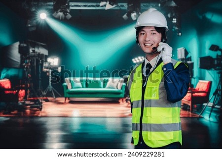 Young man in charge of studio props Royalty-Free Stock Photo #2409229281