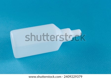 White plastic medicine bottle with blue background