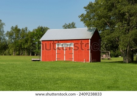 Old red barn at Chaplin Creek Historical Site in Franklin Grove, Illinois, USA. Royalty-Free Stock Photo #2409238833