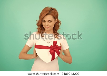 positive woman hold heart present box on blue background
