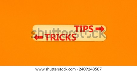 Tips and tricks symbol. Concept word Tips and tricks on beautiful wooden stick. Beautiful orange table orange background. Business and Tips and tricks concept. Copy space.