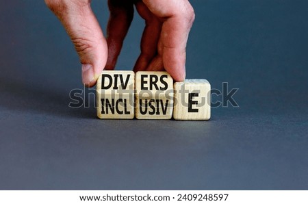 Diverse and inclusive symbol. Concept word Diverse and Inclusive on wooden cubes. Beautiful grey table grey background. Businessman hand. Business diverse and inclusive concept. Copy space.