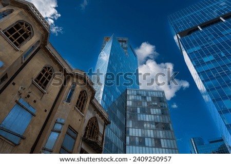 Striking image capturing the stark contrast between a dilapidated old building and a towering modern skyscraper against a dramatic sky in Tel Aviv, Israel Royalty-Free Stock Photo #2409250957