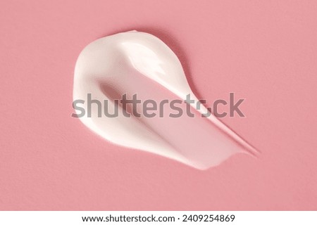 A savory smear of white cream on a pink background.