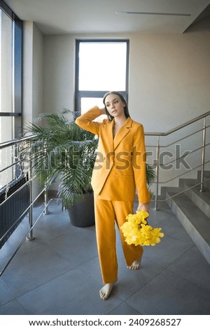 A person wearing a yellow suit indoors.