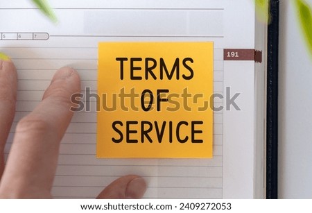 TERMS OF SERVICE text written on notebook with pen on chart