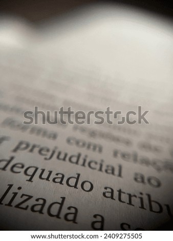 A white page of a book, with focus on some words and a blurred background