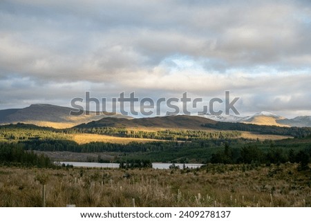 Landscape photography of the Scottish Highlands in the fall. Beautiful scene with mountains and green grass  Royalty-Free Stock Photo #2409278137