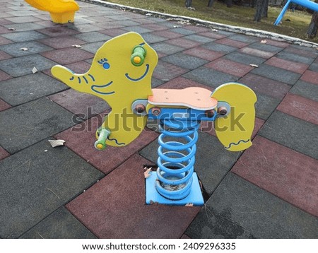 Bouncing spring toy in the park. Spring elephant toy for children in children's playground. Children's play area. Outdoor play equipment.