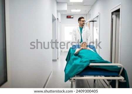 Medical professional pushing patient on gurney through hospital corridor. Patient hospital bed moved by medical staff to operating room. Male healthcare worker moving patient in another hospital room.