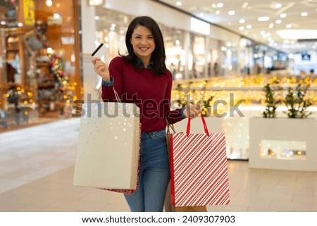 Woman holding credit card in mall. woman holding shopping bags in the mall