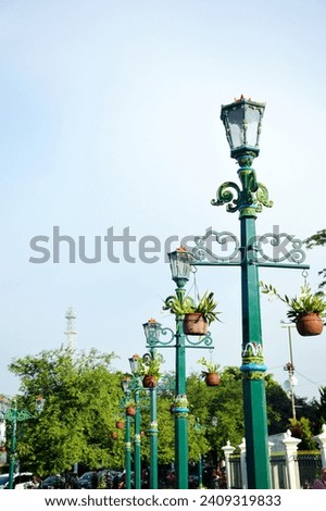 This classic design street lighting lamp made from metal and painted green is located throughout the Malioboro tourist area, Yogyakarta, Indonesia and was photographed against a clear sky background.