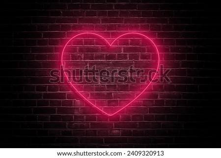 Illuminate your romance with the soft glow of a neon heart on a dark brick wall, casting a warm and intimate ambiance—a perfect visual ode to love on Valentine's Day.
