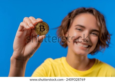 Woman with bitcoin, crypto currency. Golden coin on blue background. Digital exchange, popularity of BTC, symbol of future money, electronics industry, mining concept. High quality photo Royalty-Free Stock Photo #2409328769