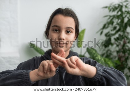 Beautiful smiling deaf girl using sign language.