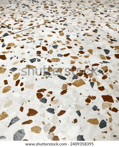 Ceramic indoor flooring tile with abstract brown, gray, and white colored scattered stone pattern design isolated on vertical photography template ratio