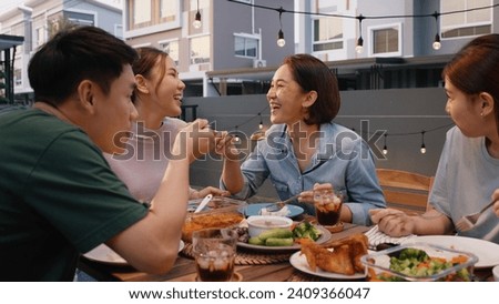 Mom enjoy thai meal cooking for family day meet talk home dining at dine table cozy patio. Group asia people young adult man woman friend fun joy relax warm night time picnic eat yummy food with mum. Royalty-Free Stock Photo #2409366047