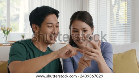 Asia people young couple relax leisure good easy time at cozy sofa home enjoy fun play phone trending filter effect selfie challenge in social media app  reel  viral video story photo shoot