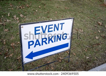 A white sign with blue lettering that reads, "Event Parking".