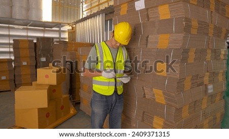 Portrait of asian engineer man order details checking goods and cardboard box with goods background in warehouse.logistic and business export.Product Distribution Logistics Center.