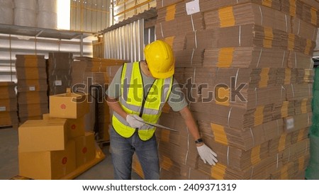 Portrait of asian engineer man order details checking goods and cardboard box with goods background in warehouse.logistic and business export.Product Distribution Logistics Center.