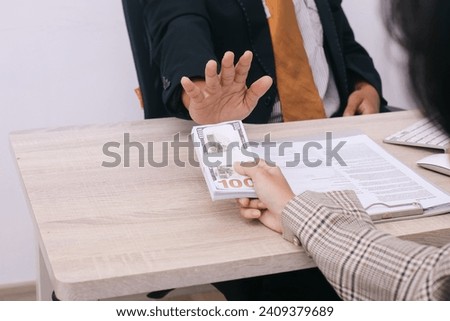 Businessman or politician say no to bribe money that offer to him in the office. Bribery, corruption and money politics concept Royalty-Free Stock Photo #2409379689