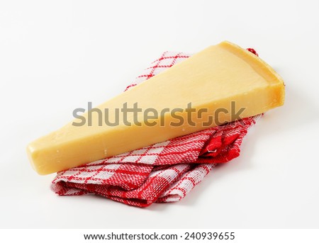 Wedge of Parmesan cheese on checked tea towel
