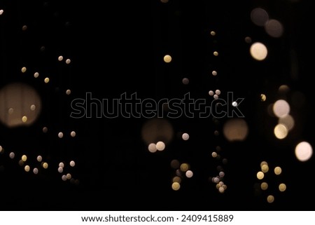 Mesmerizing light bokeh captures the enchanting dance of radiant orbs, creating a dreamlike ambiance. A celestial spectacle of blurred brilliance. Royalty-Free Stock Photo #2409415889