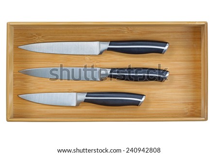 Close up horizontal image of a new wooden kitchen drawer with knife set isolated on white 