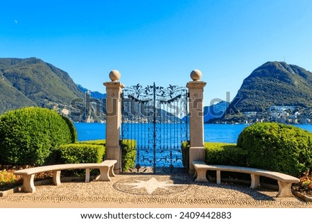 Old wrought iron gate overlooking Lake Lugano in Ciani Park, Lugano, Switzerland Royalty-Free Stock Photo #2409442883