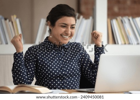 Excited indian female student feel euphoric winning grant or contest, get pleasant email on laptop, overjoyed ethnic millennial girl triumph receive approval letter on computer, success concept Royalty-Free Stock Photo #2409450081
