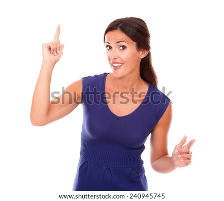 Beautiful girl with finger pointing up while looking at you in white background - copyspace