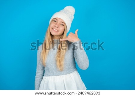 beautiful caucasian teen girl smiling doing phone gesture with hand and fingers like talking on the telephone. Communicating concepts.