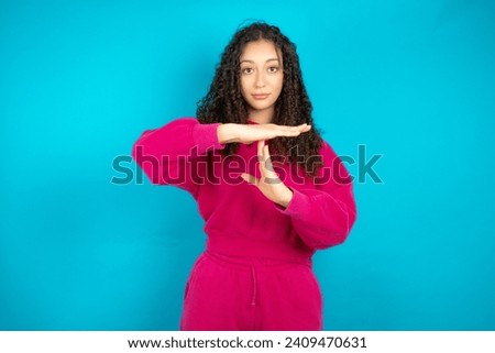teenager girl wearing pink jumper  being upset showing a timeout gesture, needs stop, asks time for rest after hard work,