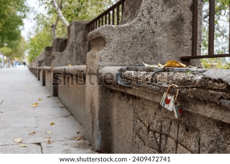 Two padlocks hooked to each other and to a bench with the heart symbol on the Paseo de la Ribera in Cordoba.