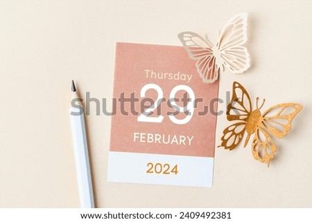 February 29th mini calendar for February 2024 and butterfly paper on yellow background. Leap year, intercalary day, bissextile. Royalty-Free Stock Photo #2409492381
