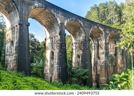A beautiful nine-arch bridge near the city of Ella in Sri Lanka. Top view, aerial photography. Royalty-Free Stock Photo #2409493755