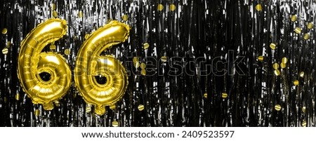 Gold foil balloon number number 66 on a background of black tinsel decoration. Birthday greeting card, inscription sixty-six. Anniversary event. Banner. copy space. Royalty-Free Stock Photo #2409523597