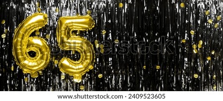 Gold foil balloon number number 65 on a background of black tinsel decoration. Birthday greeting card, inscription sixty-five. Anniversary event. Banner. copy space.