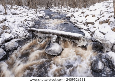Water runs in the river in winter.