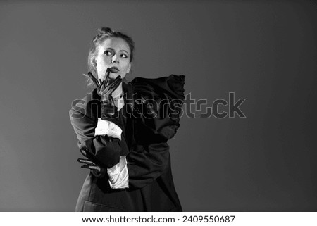 Black and white portrait of pretty young woman in black dress with gloves