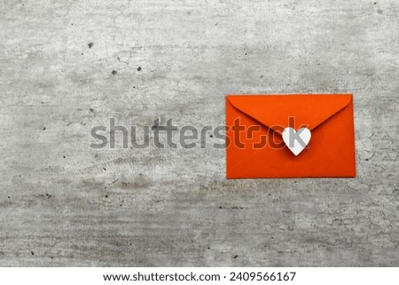 Celebrate Love: Exquisite Valentine's Day Composition with a Red Envelope Featuring a Central White Heart, Elegantly Placed on a Subtle Grey Background