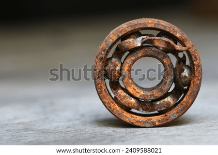old rusty and damaged ball bearing on wood table .  Royalty-Free Stock Photo #2409588021